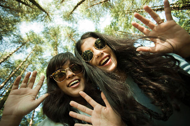 Visão de olho de verme de duas garotas felizes com sorriso dentuço. - foto de acervo