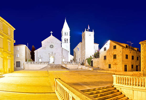 Church and stone squate in Supetar Church and stone squate in Supetar evening view, island of Brac, Dalmatia, Croatia old catholic church on island brac croatia stock pictures, royalty-free photos & images