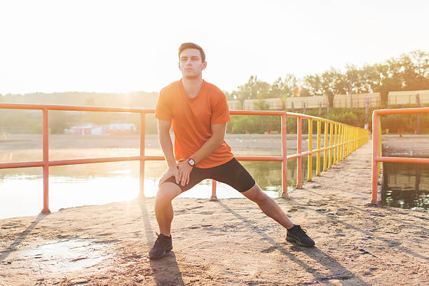 istock Fit man warming up doing lunges exercising during morning run. 606670546