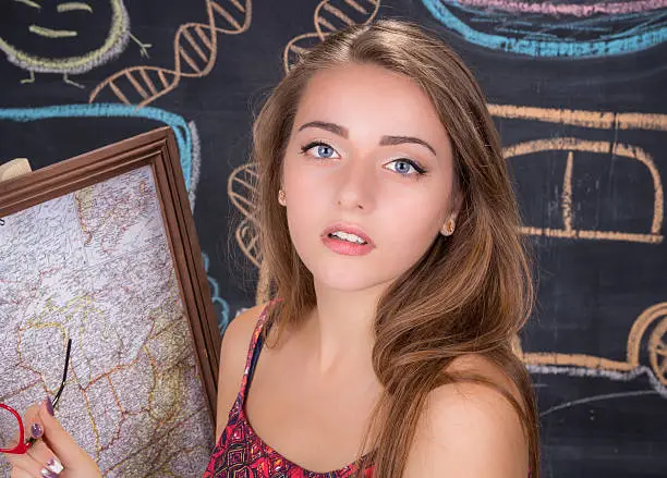 Young student girl in red dress reports on geography classes with u.s.a. map