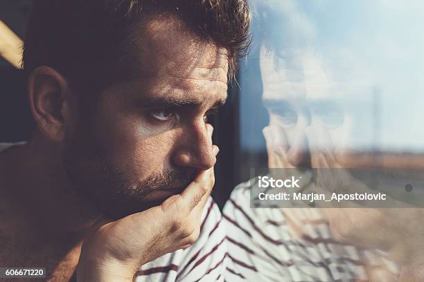 Trauriger Junger Mann Blick Durch Das Fenster Stockfoto und mehr Bilder von Männer - Männer, Traurigkeit, Depression