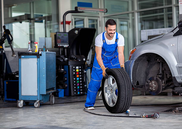 istock Smiling mechanic pushes the tire 606675702