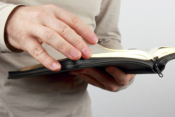 istock open book the bible in the hands of men 606677156