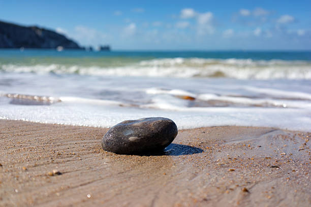 istock Pebble about to be washed up by waves 606677254