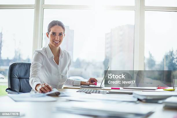 Portrait Of Happy Young Businesswoman Using Laptop At Office Desk Stock Photo - Download Image Now