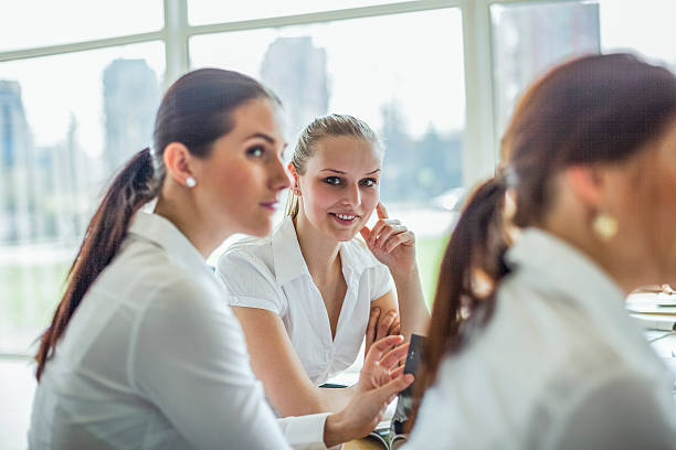 Beautiful young businesswoman with female colleagues in board room Portrait of beautiful young businesswoman with female colleagues in board room stars in your eyes stock pictures, royalty-free photos & images