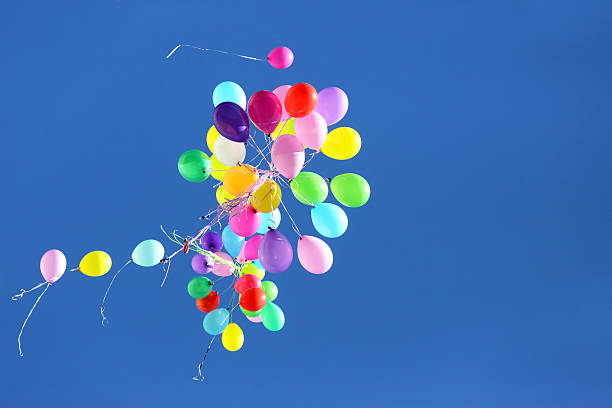 istock many multicolored balloons flying in the blue sky 606679330