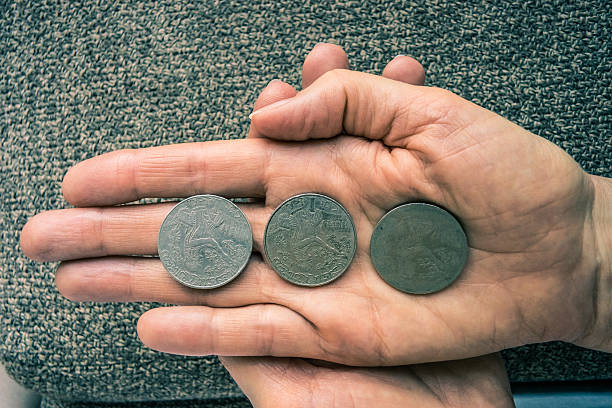 istock Three Tunisian coins on the woman's palm 606680572