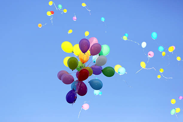 istock many multicolored balloons flying in the blue sky 606681078