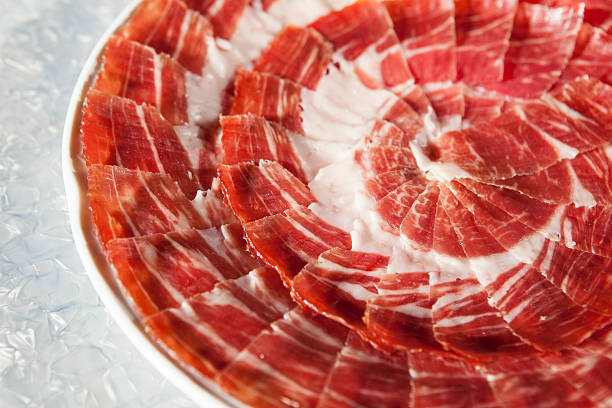 circular decorative arrangement of iberian cured ham on plate - serrano chilli pepper meat ham spain imagens e fotografias de stock