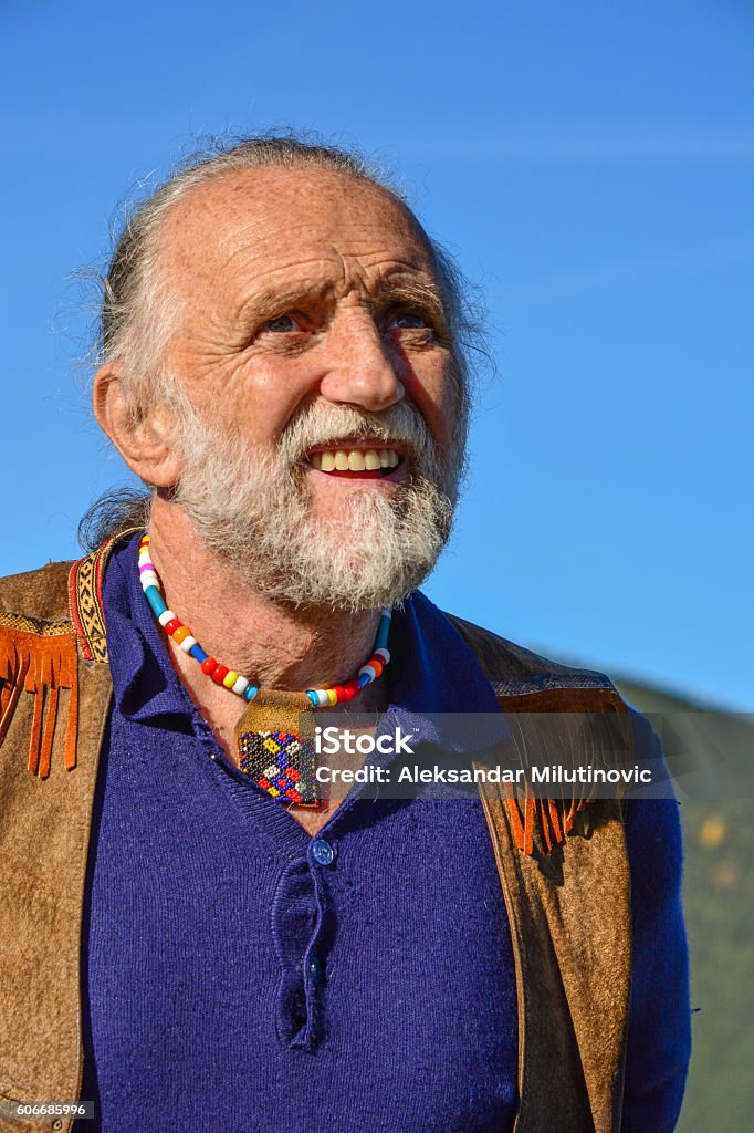 Porrait of impressive elderly man Porrait of impressive elderly man dressed in hippie style against blue sky in a bright, sunny autumn day Active Lifestyle Stock Photo
