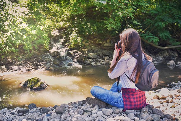 istock Young photographer in nature by the river 606705190