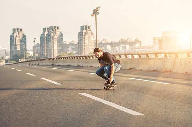 istock Skateboarder riding a skate over a city road bridge 606708762
