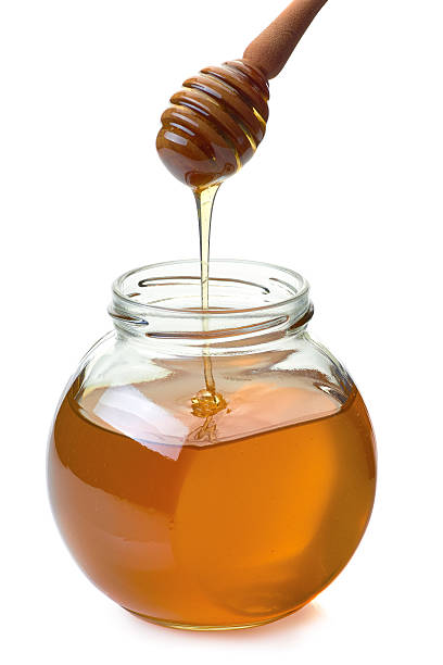 istock Jar with dripper an flowing honey on white 606710580