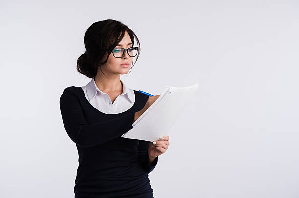 istock Thoughtful woman with papers standing isolated on a white background 606712442
