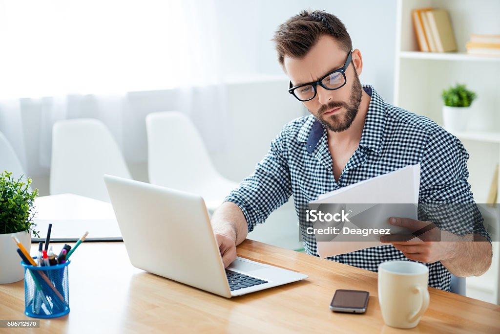 homme d’affaires concentré dans des lunettes avec contrat de lecture d’ordinateur portable - Photo de Travailleur indépendant libre de droits