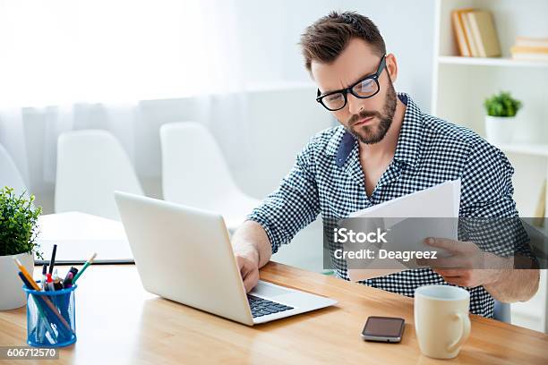 Photo libre de droit de Homme Daffaires Concentré Dans Des Lunettes Avec Contrat De Lecture Dordinateur Portable banque d'images et plus d'images libres de droit de Travailleur indépendant