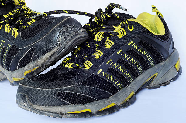 istock Black and yellow colored used running, sport shoes 606712938