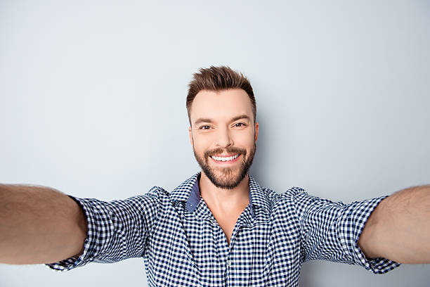 istock Cheerful handsome bearded young man making selfie 606714024