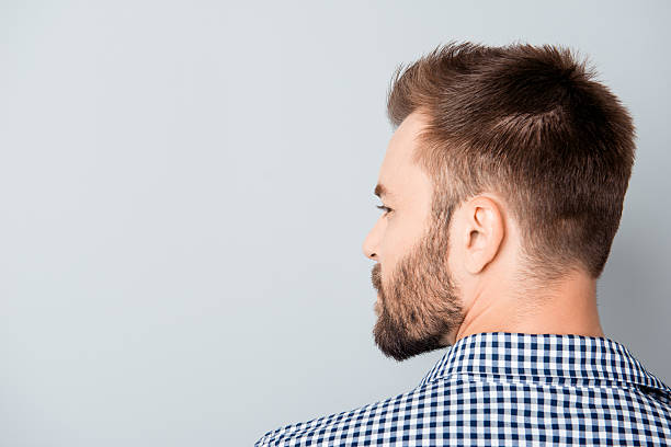 istock Back view of young bearded brunet man on gray background 606714912