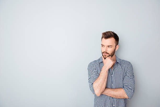 istock Concentrated thoughtful businessman touching chin on gray background 606715078