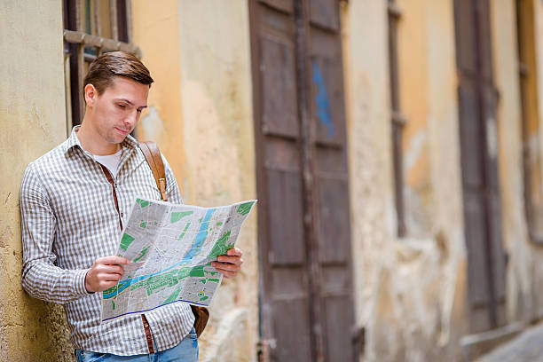 istock Man tourist with a city map and backpack in Europe 606723658