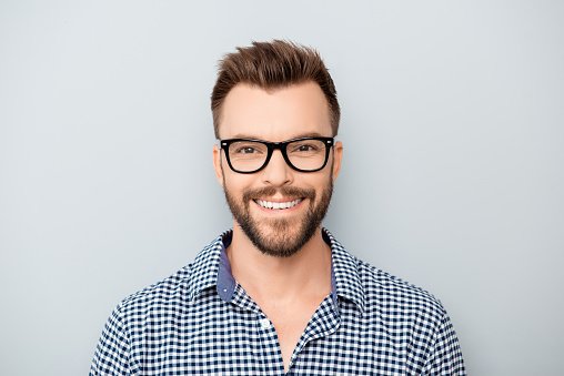 Portrait of handsome cheerful young smiling man in glasses