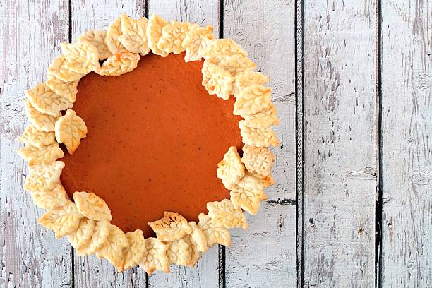 istock Thanksgiving pumpkin pie, above view on white wood 606739840