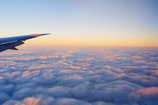 istock Cropped Image Of Airplane Flying Above Cloudscape At Sunset 606758481