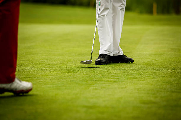 istock Low Section Of Golfers Playing At Field 606758857