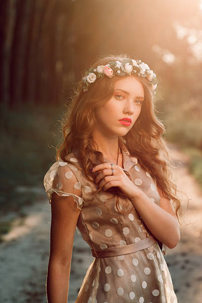 istock Attractive girl in wreath posing at sunset forest 607252876