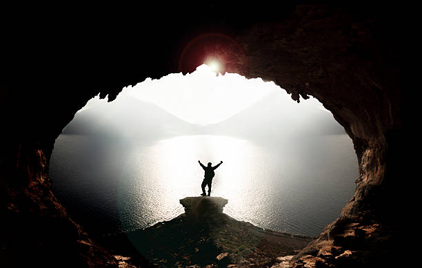 istock caves, sea and adventurous climbers 607255678
