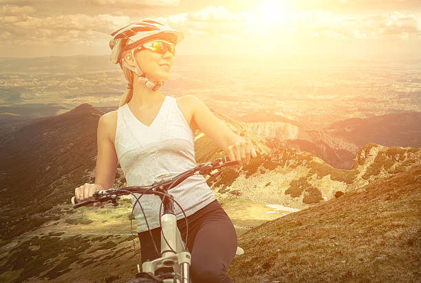 istock Woman stay on the bicycle around mountains 607256644