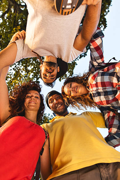 istock Below view of united friends standing embraced in a circle. 607257002