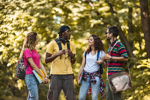 istock Group of smiling students talking to each other in nature. 607257198