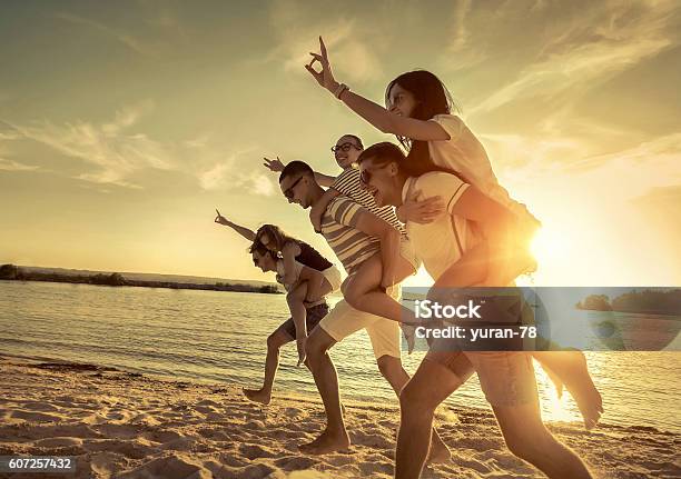 Friends Fun On The Beach Under Sunset Sunlight Stock Photo - Download Image Now - Adult, Beach, Beach Party