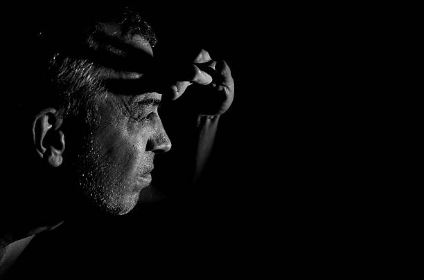 Gloomy man. Low-key black and white portrait.