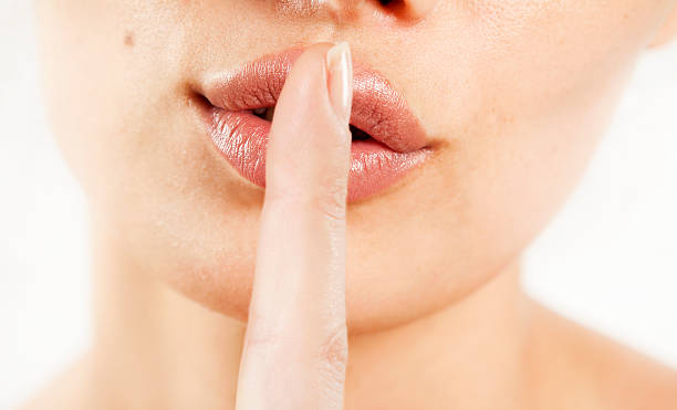 istock Close up of a woman lips with finger 607261880