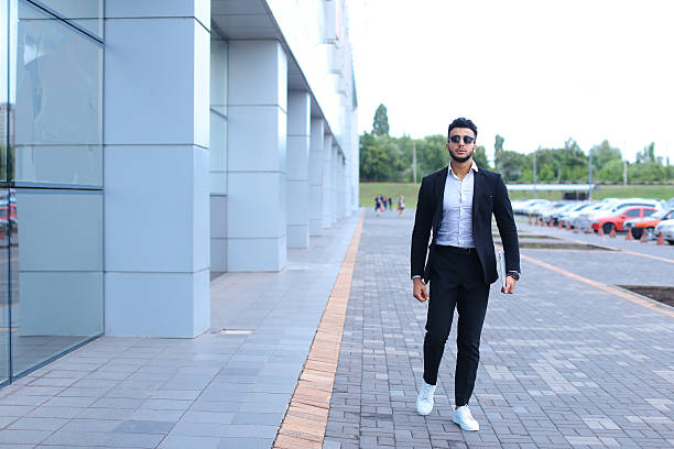 istock Arabic guy in business center stands smiling walking slow 607262752