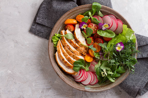 istock Spring salad with vegetables, chicken breast and edible flowe 607263512