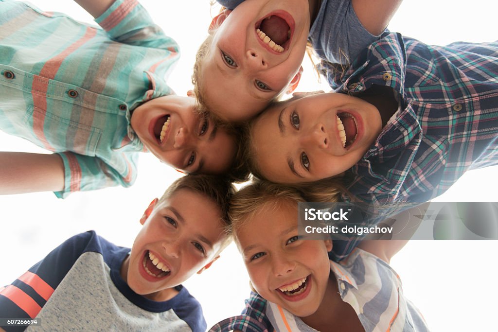 group of happy children faces in circle childhood, leisure, friendship and people concept - group of smiling happy laughing children faces in circle Child Stock Photo