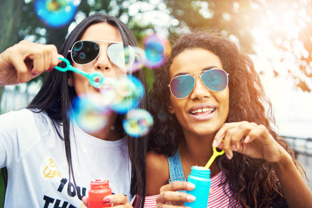 istock Diverse friends blow bubbles at the camera 607268366