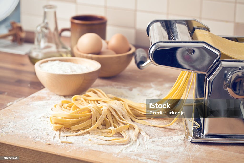 fresh pasta and pasta machine fresh pasta and pasta machine on kitchen table Making Stock Photo