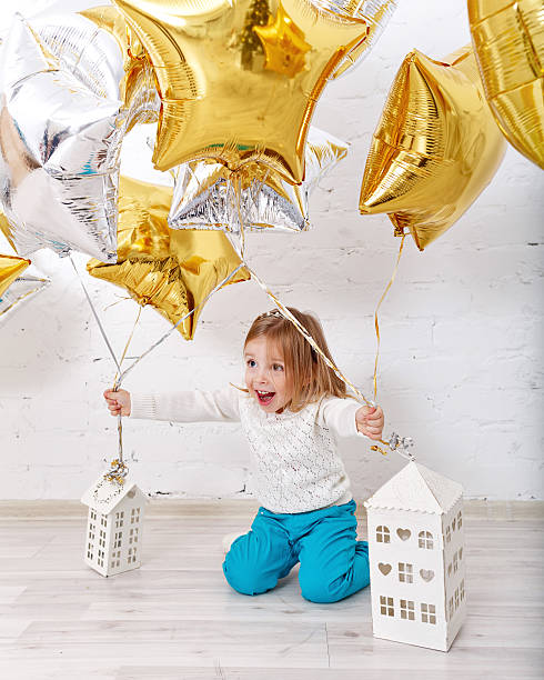 istock Little girl playing with balloons. 607272372
