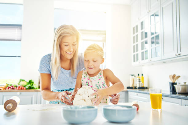 istock Happy child learning to bake with her mother 607273080