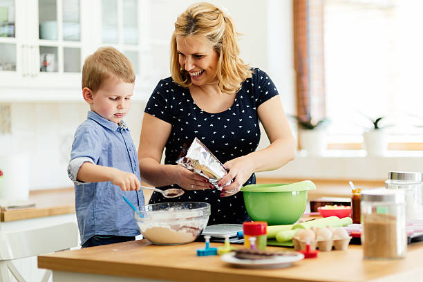 istock Mother and child preparing cookies 607274394