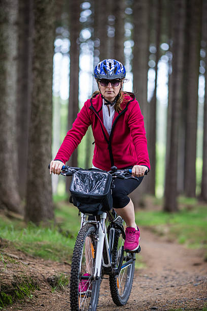 istock Woman riding bike on forest trails 607278080
