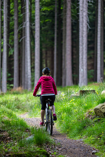 istock Woman riding bike on forest trails 607278156