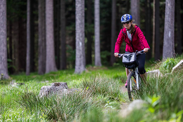 istock Woman riding bike on forest trails 607278256
