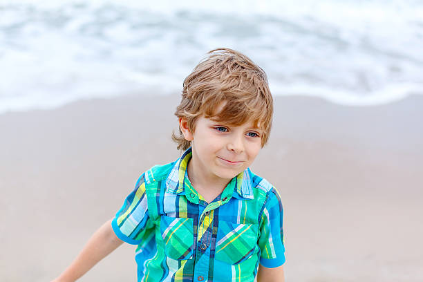 istock little kid boy on the beach of ocean 607279096